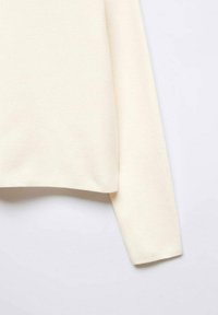 Pull à manches longues écru avec un ourlet droit, vu de profil sur un fond clair.