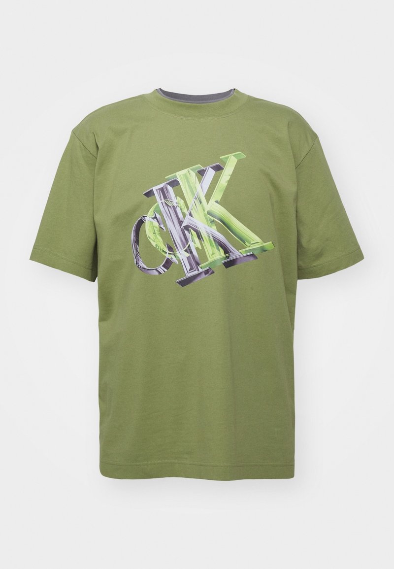 Camiseta de algodón color verde oliva con mangas cortas. Presenta un gran gráfico en texto negro y verde en la parte frontal. Cuello redondo con ribete acanalado.