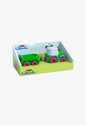 Green plastic toy tractor with gray accents, red wheels, and a detachable trailer. Packaged in a light green box with branding and illustrations.