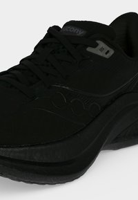 Μαύρο αθλητικό παπούτσι Saucony με κορδόνια μπροστά, μαλακή σόλα και διακριτικό λογότυπο της μάρκας στο πλάι και στη γλώσσα.