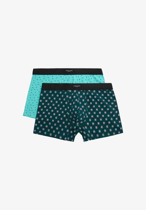 Dos pares de calzoncillos bóxer para hombre con cinturillas negras, uno turquesa con pequeños estampados de palmeras, otro verde oscuro con patrones de calaveras rojas y blancas.