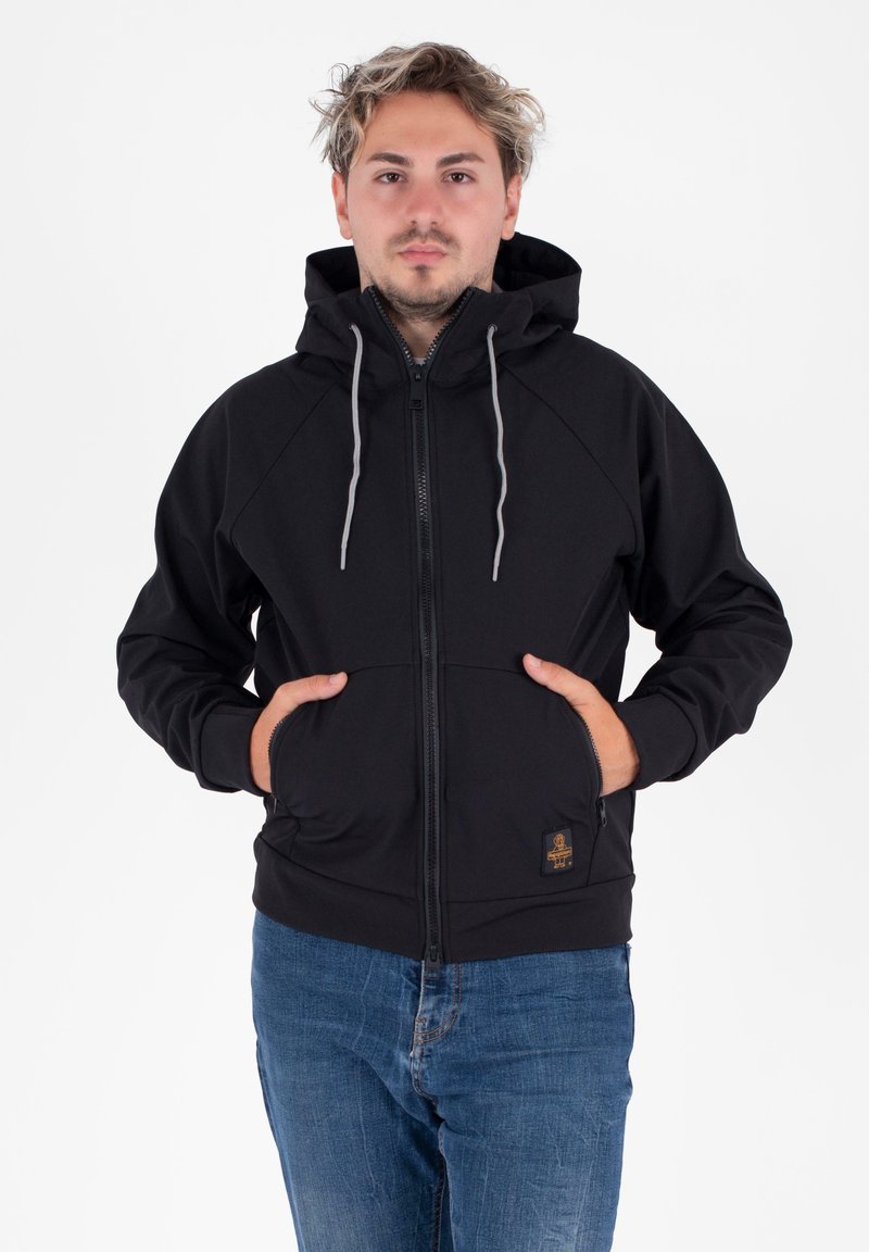 Felpa nera con zip, cappuccio foderato, cordini grigi, tasche frontali e una piccola patch con logo in basso a sinistra. Realizzata in un materiale morbido.
