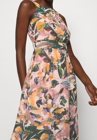 Vestido sin mangas con estampado floral en tejido ligero, con una paleta de colores pastel en rosa, naranja y verde, cintura ajustada y falda fluida.