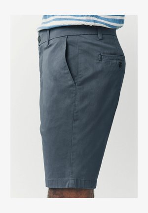 Halli puuvillased lühikesed püksid, millel on klassikaline disain, küljetaskud, tagatasku nööbiga sulgemisega ning korras õmblused servades.