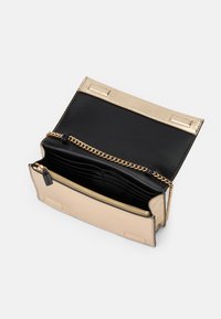 Metallic gold and black handbag with a chain strap, zippered pocket, and multiple card slots; smooth texture and structured design.