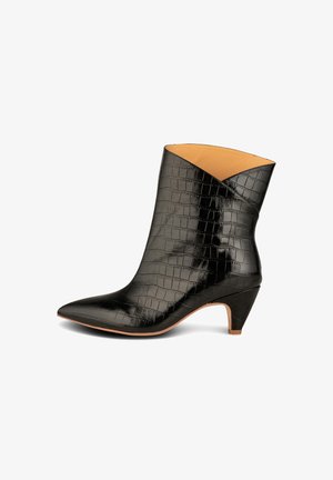 Bota de cuero negra hasta media pantorrilla con textura de cocodrilo, punta puntiaguda y tacón bajo inclinado, cuello inclinado con forro interior color tostado.