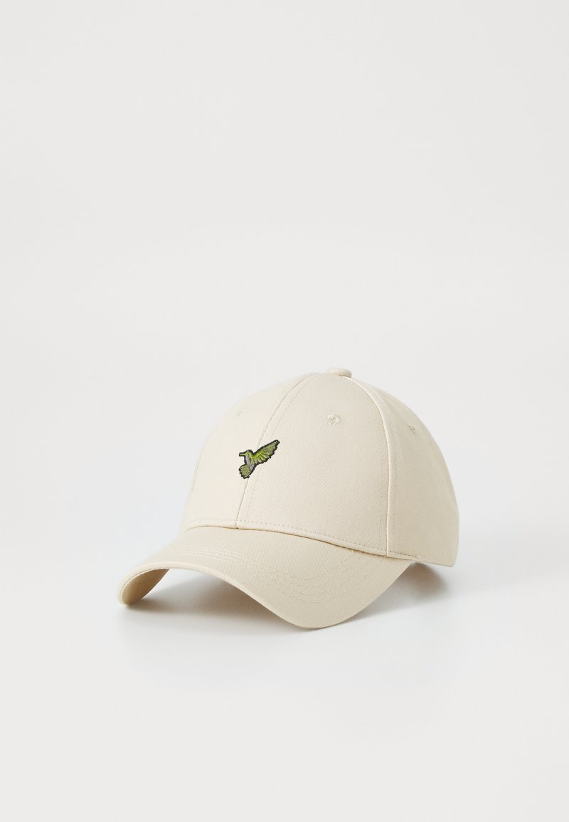 Basebollkeps i beige bomull med en krökt skärm och broderad grön kolibri-design på frontpanelen.