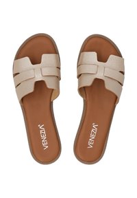 Beige slipper sandalen met een gestructureerde bovenkant en kruislingse banden. De gevoerde binnenzool is bruin, met een gegroefd rubberen buitenzool.