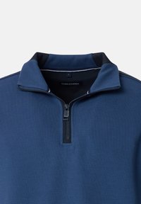 Dunkelblauer Halbzip-Pullover mit strukturiertem Stoff, kontrastierendem Kragen und dezenten Streifenakzenten am Hals. Markentag sichtbar.