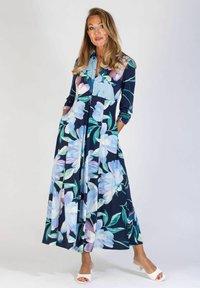 Kwiatowa długa sukienka z ciemnogranatowym tłem, ozdobiona dużymi jasnoniebieskimi i fioletowymi kwiatami, z dwiema bocznymi kieszeniami oraz zapięciem na guziki z przodu.