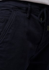 Pantaloni di cotone blu navy con vestibilità comoda, vita regolabile con cordino e tasche laterali con dettagli di cucitura in vista.