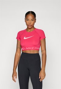Rosa croppet treningsgenser med rund hals og korte ermer, med en hvit Nike-logo og en teksturert midjebånd med "NIKE PRO" i rosa.
