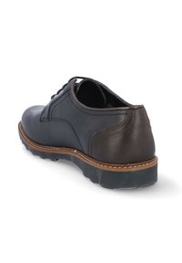 Zapato de cuero negro con un acento de cuero marrón en el talón, punta redonda, diseño con cordones, costuras en contraste y suela de goma texturizada.