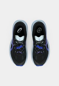 Μαύρα αθλητικά παπούτσια με υφή στην επιφάνεια, μοβ λεπτομέρειες και μαλακή μπλε σόλα. Διαθέτουν κορδόνια και διακοσμητικά σχέδια στο πλάι.