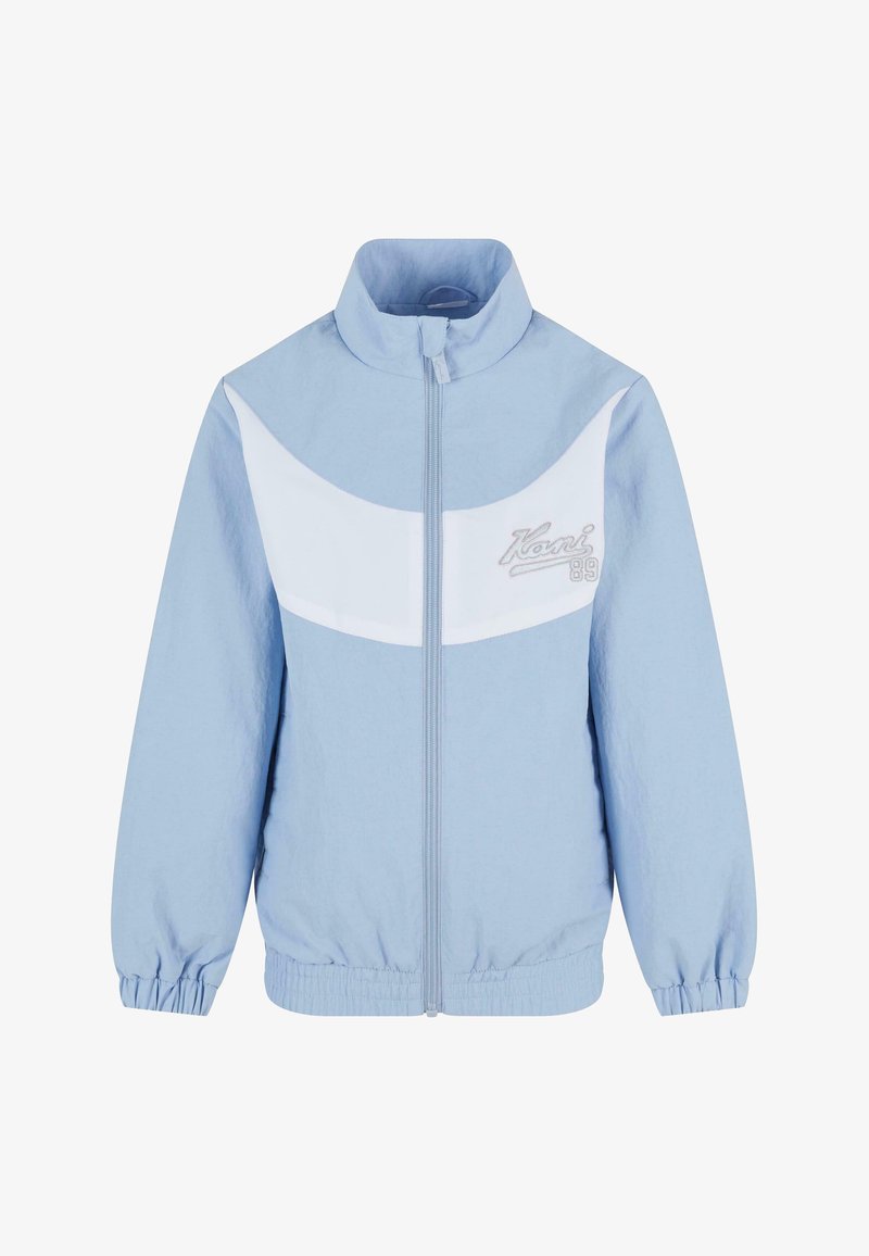 Hele sinine jakk valge paneeliga rinna kohal, kõrgema kaelusega, lukuga ees, elastsete mansettidega ja kõrvale tikitud logodetailiga.