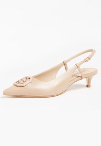 Sandal à talon kitten beige à bout pointu avec un embleme décoratif à l'avant et une bride à boucle ajustable.