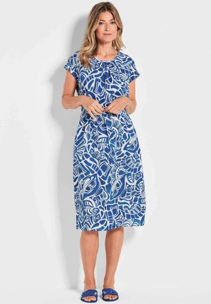 Robe à motifs bleus et blancs avec des manches courtes, un col rond et une coupe évasée, présentant un design abstrait distinctif.