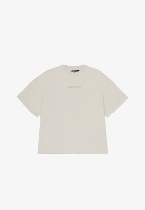 Light beige oversized T-shirt made of cotton, featuring short sleeves and a crew neckline. "PEGADOR" logo printed subtly on the front.