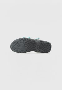 Black rubber shoe sole with intricate swirling tread patterns; features teal accents along the sides. Smooth texture, rounded shape.