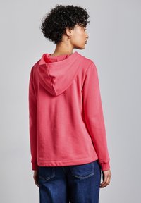 Sudadera con capucha rosa hecha de suave algodón, con un corte relajado, puños acanalados y un bolsillo canguro en una tela suave.