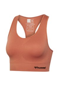 Naadloze sportbeha in roestkleur met racerback-ontwerp, hummel-logo aan de zoom en een binnenlabel met maat- en wasinstructies.