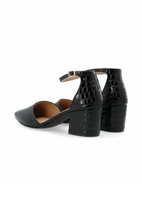 Talons en simili-crocodile noir avec un bout pointu, une bride de cheville et un talon carré texturé. L'intérieur est beige.