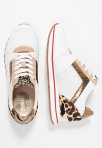 Weiße Sneaker mit goldenen Akzenten, Leopardenmuster-Details, beigem Wildleder und einer strukturierten Stoffoberfläche. Gummisohle mit rotem Streifen.