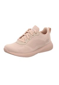 Zapatilla deportiva de color rosa claro con parte superior de tejido texturizado, cierre de cordones, suela tipo cojín y sutil detalle del logotipo en el costado.