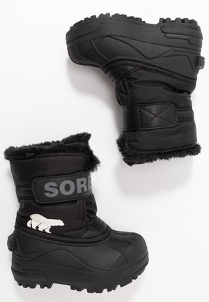Botas de invierno negras, impermeables y hechas de material sintético, con un forro esponjoso, la marca Sorel y un gráfico de un oso polar blanco.