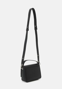 Borsa a tracolla nera con forma rettangolare, realizzata in materiale testurizzato, dotata di un manico corto e di una lunga tracolla regolabile, con dettagli in metallo di colore argento.