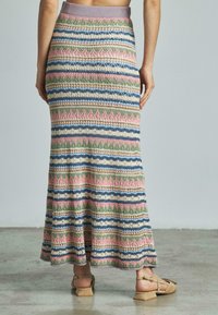 Gebreide maxi-rok met meerkleurige strepen in roze, blauw, groen en crème. Zachte textuur, elastische tailleband, vloeiende zoom.