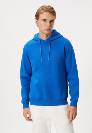 Blauwe hoodie met een trekkoord, gemaakt van zachte katoen. Heeft een kangoeroezak, ribbels aan de mouwen en onderkant; gladde textuur en levendige kleur.