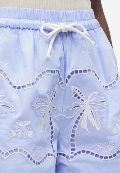 Short bleu clair avec palmiers brodés blancs, motifs de vagues et cordon blanc noué en nœud à la taille élastique.