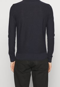 Dunkelblau gestrickter Pullover mit langen Ärmeln, geripptem Saum und Bündchen, der eine glatte Textur und ein klassisches Fit-Design aufweist.