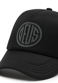 Cappello nero in tessuto, con un patch rotondo e in rilievo grigio sulla parte frontale. Visiera curva con dettagli di cucitura visibili.