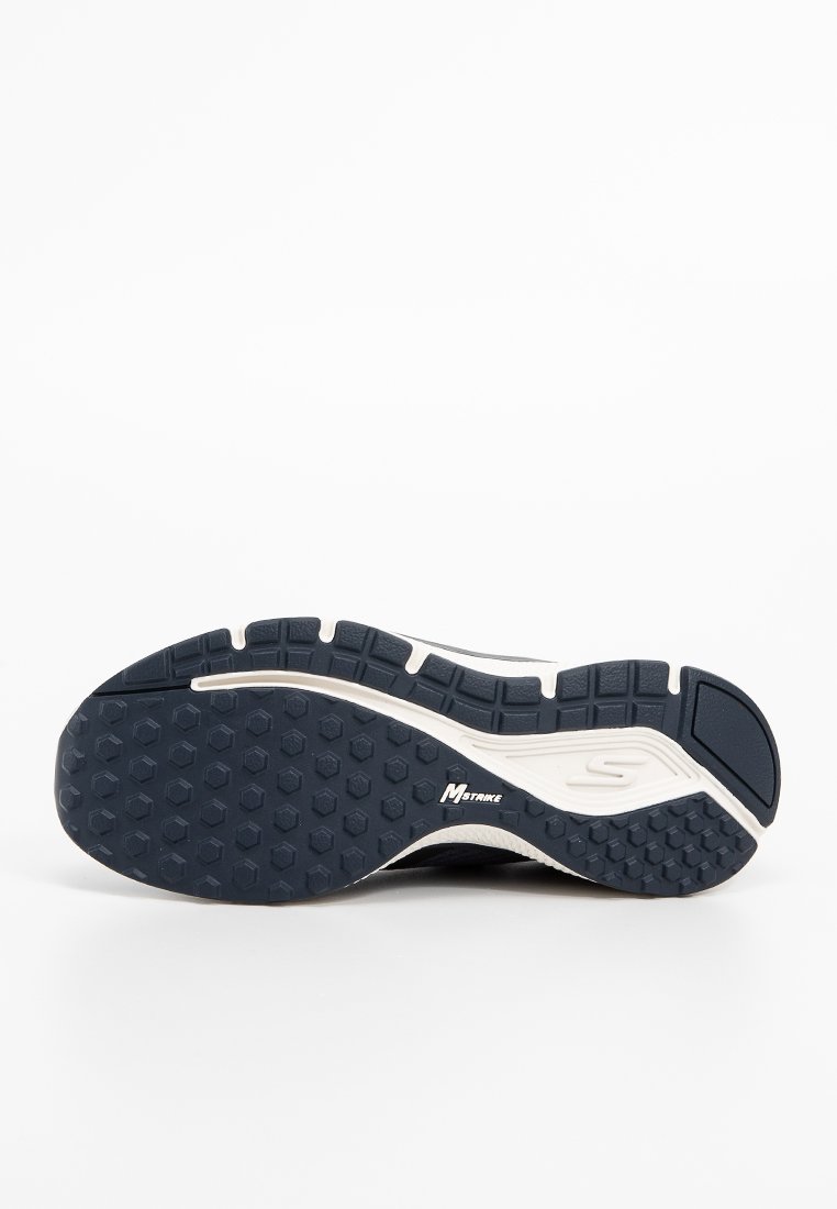Semelle de chaussure avec une texture antidérapante, en matériau en caoutchouc bleu foncé, avec des motifs hexagonaux et un bord de couleur claire. Logo présent sur le côté.