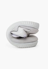 Sneaker bianco piegato con tomaia in pelle liscia, accenti in suede testurizzato, suola in gomma e interno imbottito per il comfort.