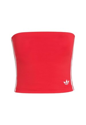 Červený crop top bez ramienok vyrobený z elastického materiálu s bielymi bočnými pruhmi a bielym logom v dolnom ľavom rohu. Hladká textúra.