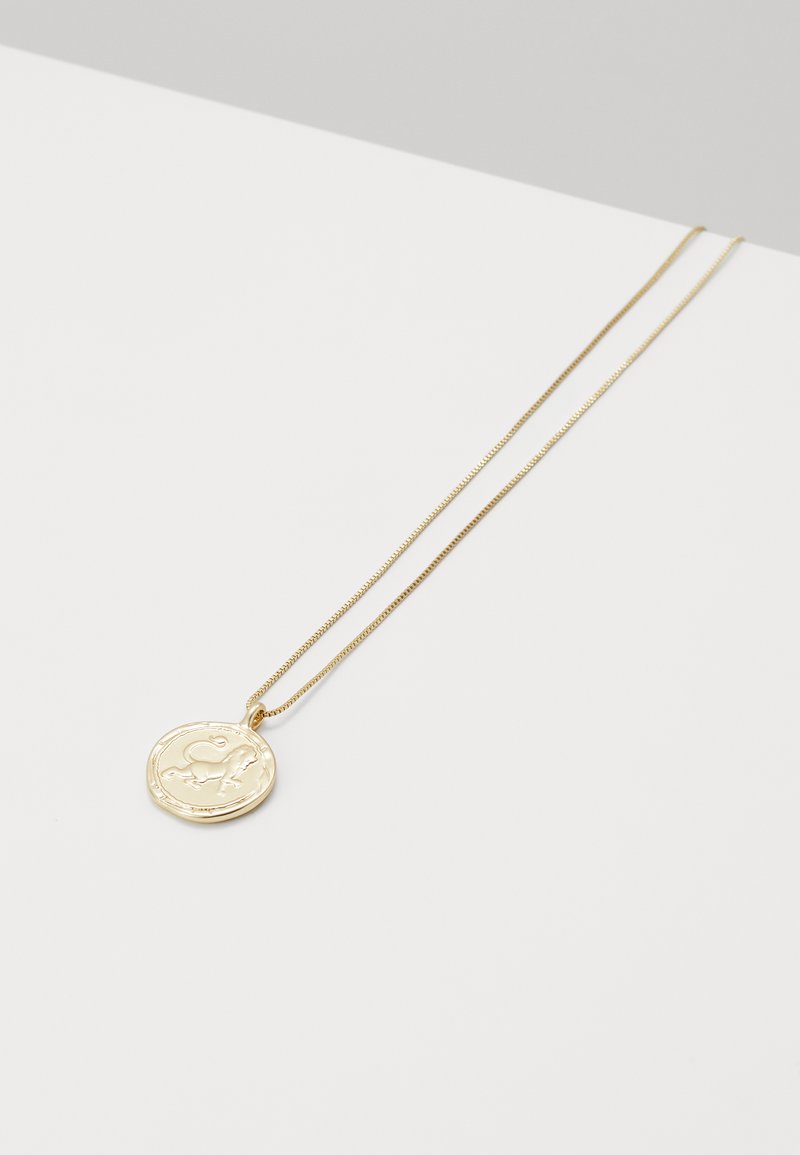 Collar en tono dorado con un colgante redondo de diseño texturizado, suspendido en una cadena delgada y delicada.