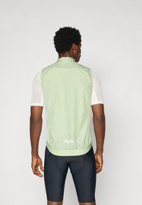 Hellgrüwestes Radfahrweste in einem aerodynamischen Design, mit einem hohen Kragen, elastischem Saum und Logo auf der Rückseite. Über einem kurzärmeligen Oberteil getragen.