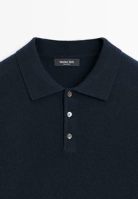 Navy blue polo shirt made of soft fabric; features a classic collar, three button placket, and a label with "Massimo Dutti."