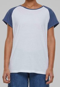 Kortærmet T-shirt med hvid krop og blå raglanærmer. Fremstillet af blødt stof med rund halsudskæring og afslappet pasform. Minimalistisk design.