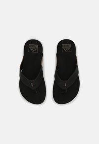 Black flip-flops with a smooth leather strap and cushioned sole, featuring the "Reef" logo in gold on the footbed and side accents.