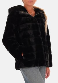 Zwarte nepbont pufferjack met capuchon, met een horizontaal gestikt ontwerp, ritssluiting en zijzakken. Zachte textuur met glans.