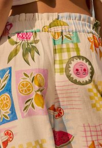 Kortbyxor i bomull med ett färgglatt mönster av frukter och geometriska former, som innehåller citroner, vattenmeloner och en leende sol, med elastisk midja.