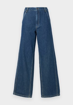 Viddebenede jeans i mørkeblå denim. Har høy midje, rette ben og markante sømmer, med glidelås og knappefeste.