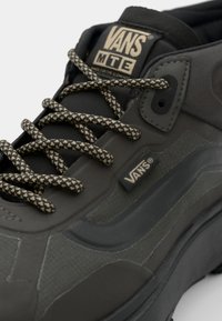 Svarte Vans MTE-sneakers med teksturert syntetisk overdel, polstret krage og flate svarte og brune mønstrede snorer med logo-detaljer.