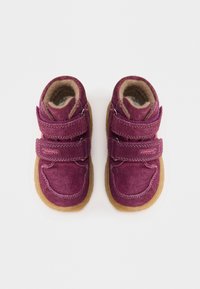 Paarse suède peuter schoenen met twee klittenbandsluitingen, een tan voering en rubberen zolen. Ronde neus en zichtbare stikselaccenten.