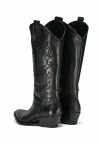 Bottes de cowboy en cuir noir avec des pointes arrondies, motifs de coutures tonales complexes et petit talon. Équipées de languettes pour un enfilage facile.