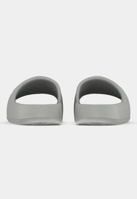 Hallid avatud varbaga libisemiskindlad kingad, millel on sile pind, ümmargune disain ja madal profiil. Pehme materjal omab minimalistlikku stiili.